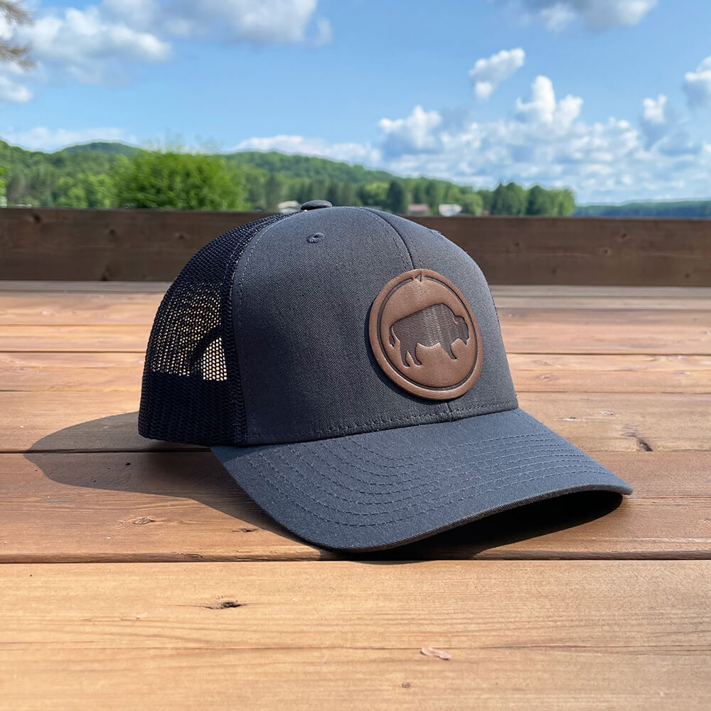Brown and khaki trucker hat with full-grain leather patch of Bison | BLACK-004-010, CHARC-004-010, NAVY-004-010, HGREY-004-010, MOSS-004-010, BROWN-004-010
