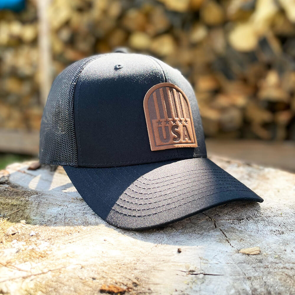 Black trucker hat with full-grain leather patch of USA Crest | BLACK-003-013, CHARC-003-013, NAVY-003-013, HGREY-003-013, MOSS-003-013, BROWN-003-013