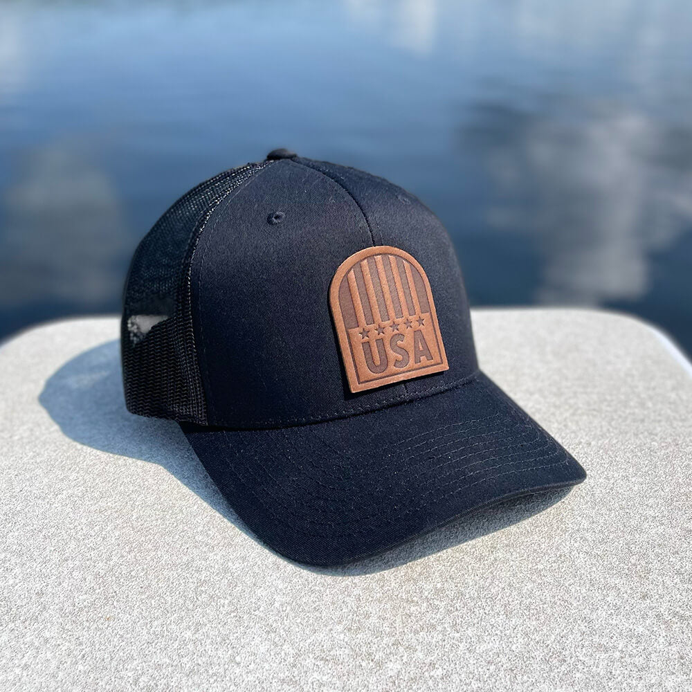 Black trucker hat with full-grain leather patch of USA Crest | BLACK-003-013, CHARC-003-013, NAVY-003-013, HGREY-003-013, MOSS-003-013, BROWN-003-013