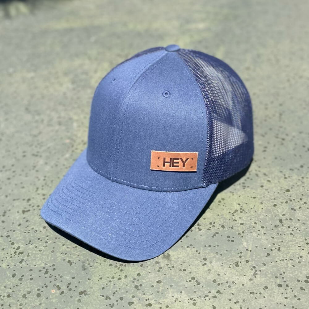 Navy trucker hat with full-grain leather patch of Custom Text | BLACK-001-001, CHARC-001-001, NAVY-001-001, HGREY-001-001, MOSS-001-001, BROWN-001-001