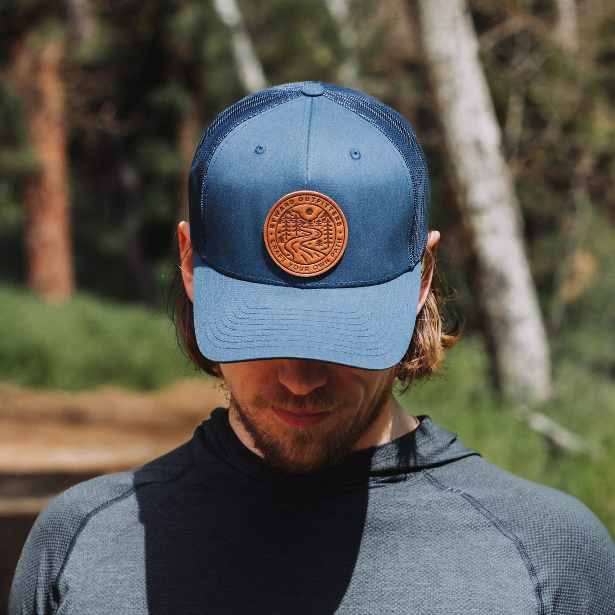 Navy trucker hat with full-grain leather patch of Winding Wilderness | BLACK-005-004, CHARC-005-004, NAVY-005-004, HGREY-005-004, MOSS-005-004, BROWN-005-004