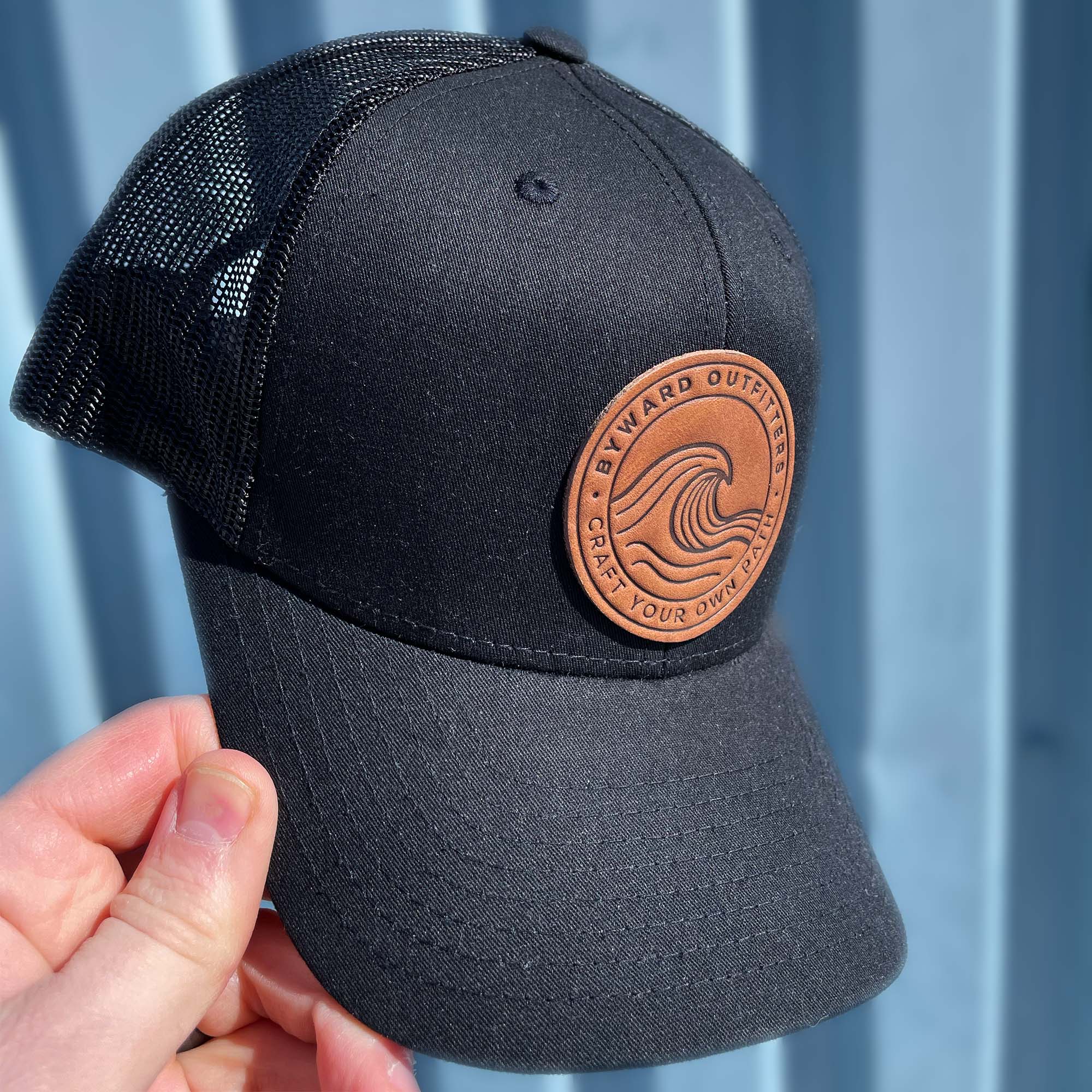 Black trucker hat with full-grain leather patch of a Rolling Wave | BLACK-005-003, CHARC-005-003, NAVY-005-003, HGREY-005-003, MOSS-005-003, BROWN-005-003